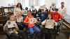 Zuniga and Bhavana Palapati pose with students from Beach’s class as they hold up science- and SDSU-inspired art they created ahead of their lab visit (Bryana Quintana / SDSU)