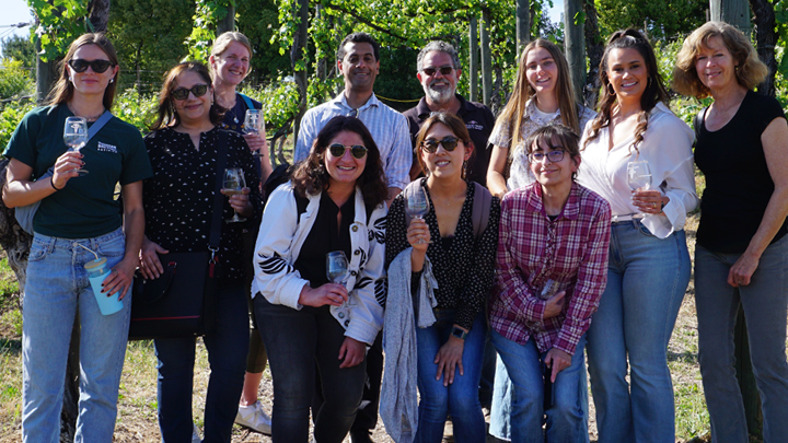 SDSU students smile for photo in a sunny vineyard in Temecula, California.