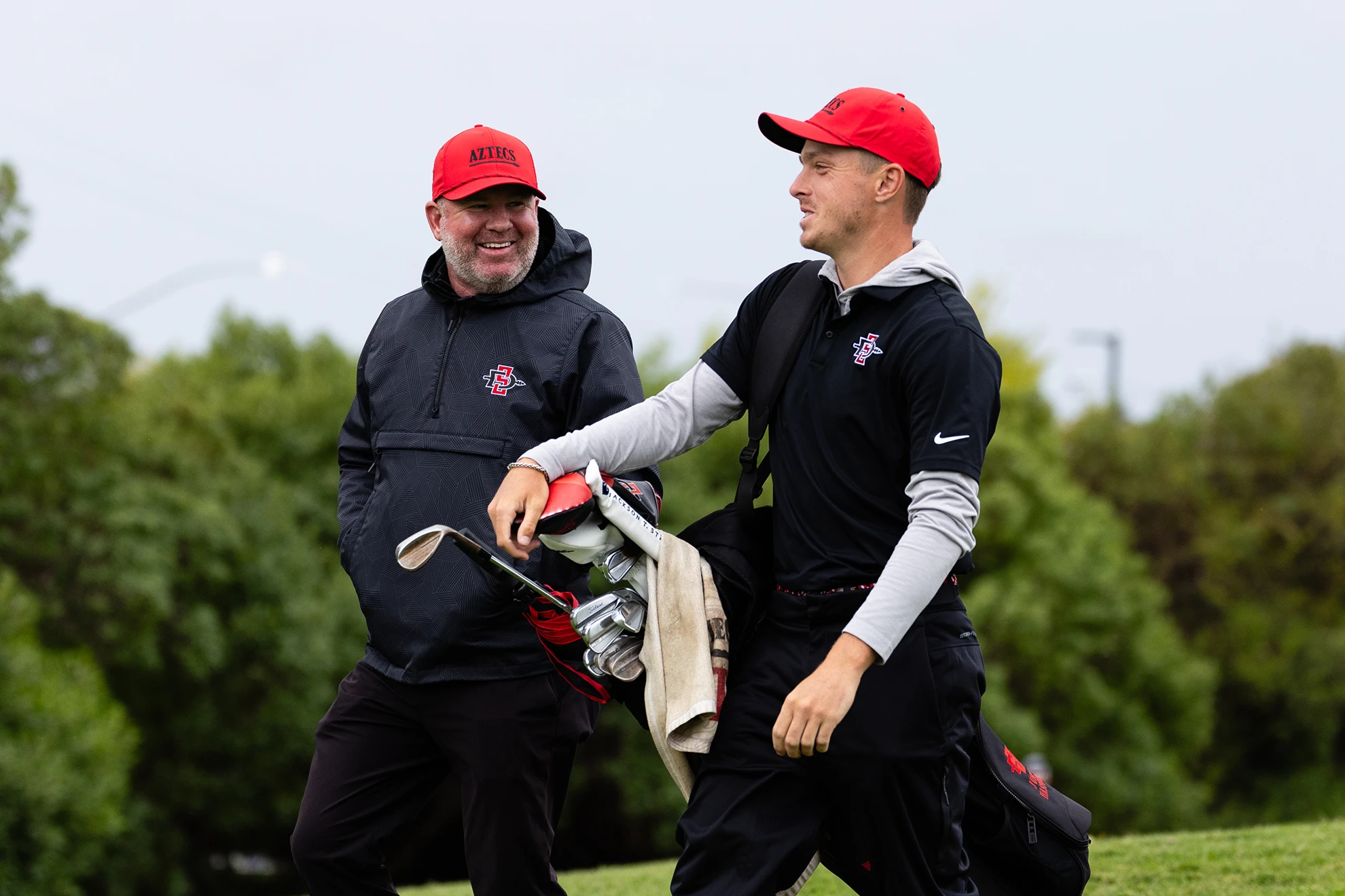 Aztecs Golf Coach Ryan Donovan walks the course with senior Justin Hastings.  (Derrick Tuskan/SDSU)