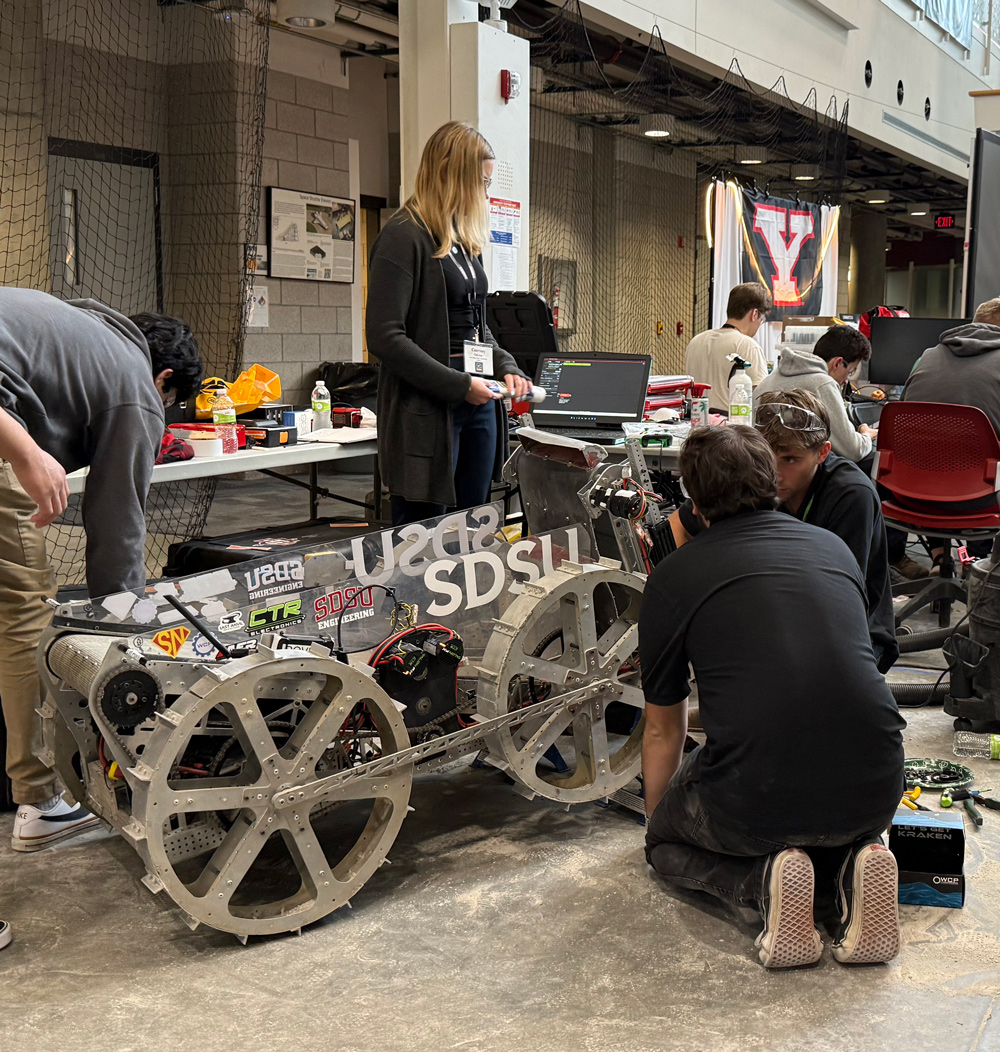 Members of Team CREED made final adjustments to their robot before the competition. (SDSU)